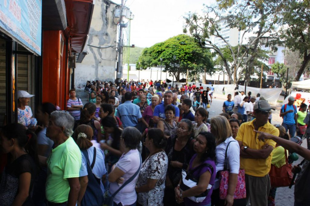 Colas en bancos de valencia para depositar billetes de 100 bolívares.