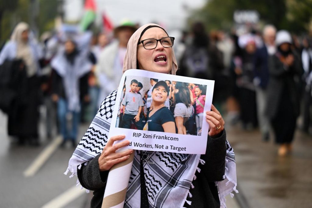 Melbourne (Australia), 03/04/2024.- A person holding a placard picturing Australian aid worker Zomi Frankcom marches to the Parliament of Victoria during a Pro-Palestine demonstration in Melbourne, Australia, 03 April 2024. Australian woman Zomi Frankcom is among a group of aid workers killed by an Israeli air strike while they were delivering food in Gaza. (Protestas) EFE/EPA/JAMES ROSS AUSTRALIA AND NEW ZEALAND OUT