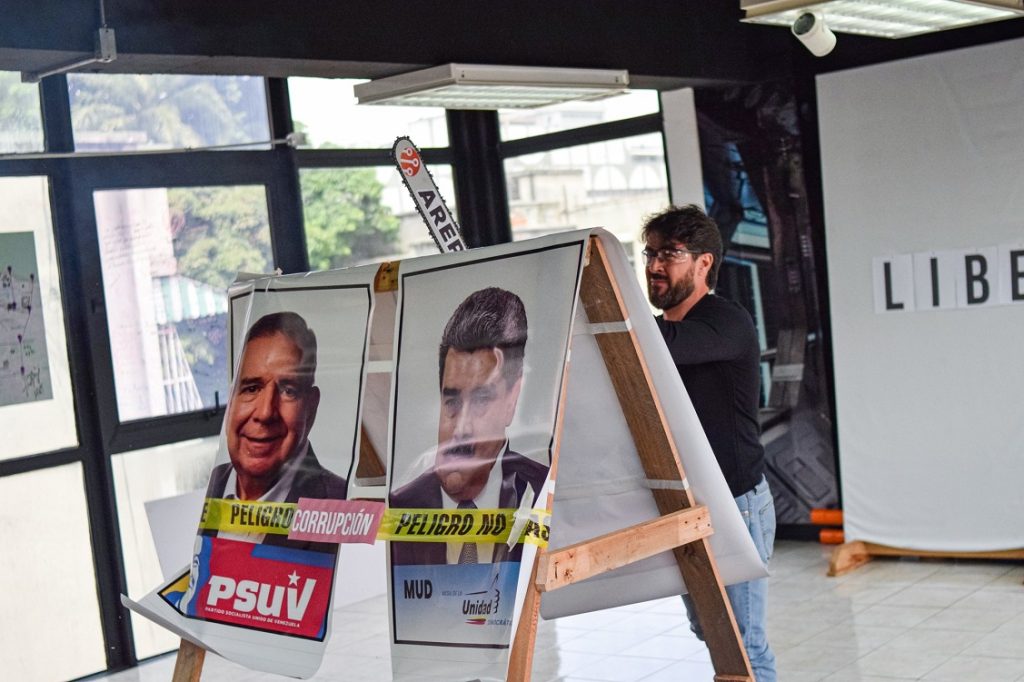 Daniel Ceballos corta con una motosierra afiches de Maduro y de González Urrutia