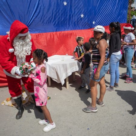 Un Santa Claus y varios voluntarios -la mayoría periodistas- entregaron este sábado regalos a 350 niños de una comunidad de Caracas. (Foto EFE)