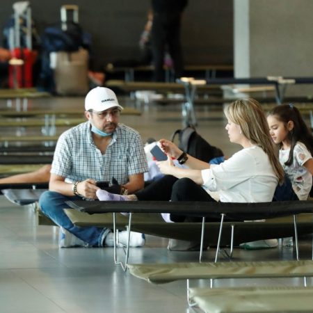 Viajeros esperan en una sala especial habilitada este sábado, en el aeropuerto internacional El Dorado, en Bogotá. Foto EFE