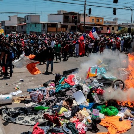 Un grupo de personas quemó carpas que eran utilizadas por extranjeros para pernoctar en plazas y playas, durante una marcha contra la migración irregular en Iquique. Foto EFE