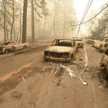 A fallen power line is seen on top of burnt out vehicles on the side of the road in Paradise, California after the Camp fire tore through the area on November 10, 2018. - Firefighters in California on November 10 battled raging blazes at both ends of the state that have left at least nine people dead and thousands of homes destroyed, but there was little hope of containing the flames anytime soon. So far, all nine fatalities were reported in the town of Paradise, in Butte County, where more than 6,700 buildings, most of them residences, have been consumed by the late-season inferno, which is now California's most destructive fire on record. (Photo by Josh Edelson / AFP)