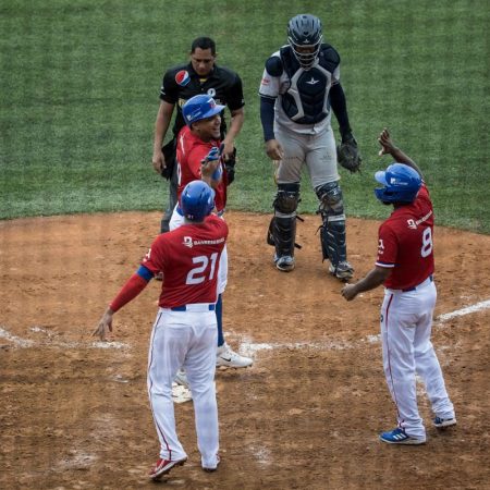 Jugadores de Los Tigres de Licey celebran una carrera . Foto EFE