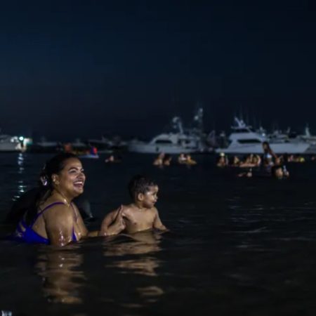 Una madre se baña en playa  Sonrisa con su hijo en Puerto Cabello. Fotografía de archivo: Armando Díaz.