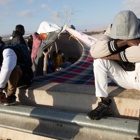 Migrantes permanecen a un lado de la vía mientras esperan soluciones a su situación migratoria. Foto EFE