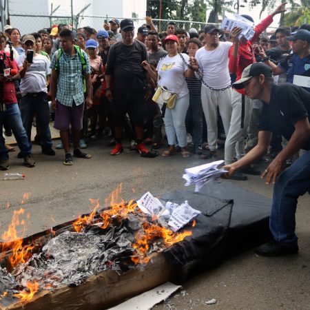 Migrantes protestan con un ataúd y las manos encadenadas en la frontera sur de México