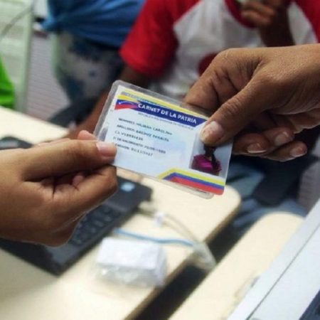 Entrega de bono con carnet de la patria.