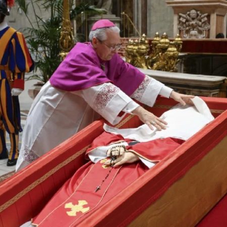 El maestro de ceremonias del Vaticano, el arzobispo Diego Giovanni Ravelli, cubre el rostro del difunto papa Francisco con un paño de seda antes de cerrar su ataúd en la basílica de San Pedro, en el Vaticano, el 25 de abril de 2025 (Foto: AP)