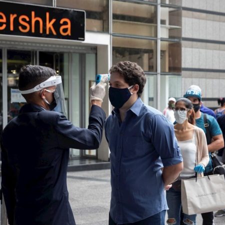 Un oficial de seguridad toma la temperatura de un usuario del Centro Comercial El Recreo, este lunes, en Caracas (Venezuela). EFE