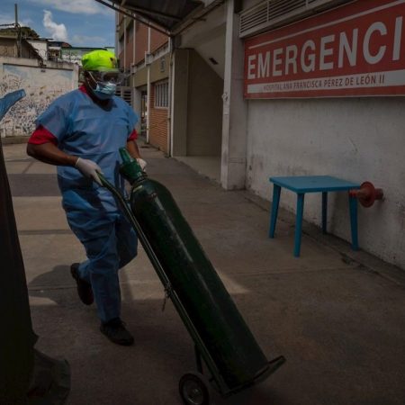 Un trabajador carga una bombona de oxigeno, el 26 de marzo del 2021, en el área de emergencias de un hospital público, en Caracas (Venezuela). EFE